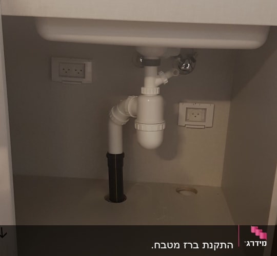 צנרת פלסטיק מתחת לכיור עם ברז